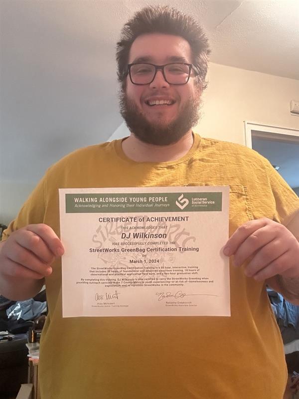 Photo of DJ holding a graduation certificate
